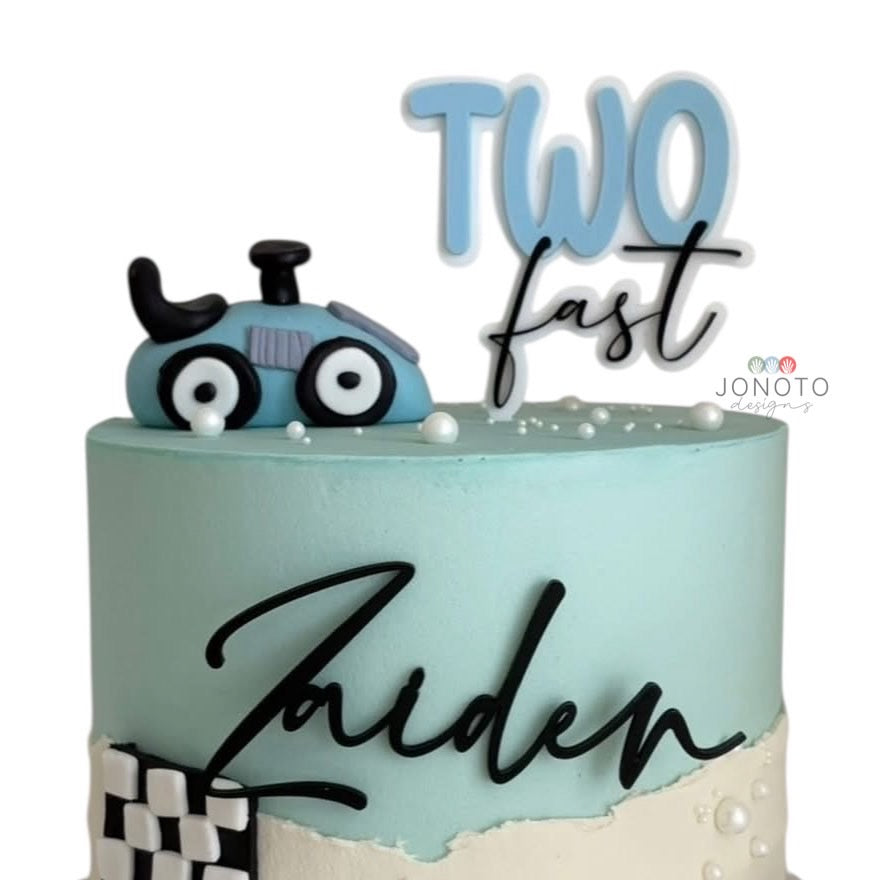 Light blue cake with a toy car and 'Two fast Zaiden' text, featuring the JONOTO brand.