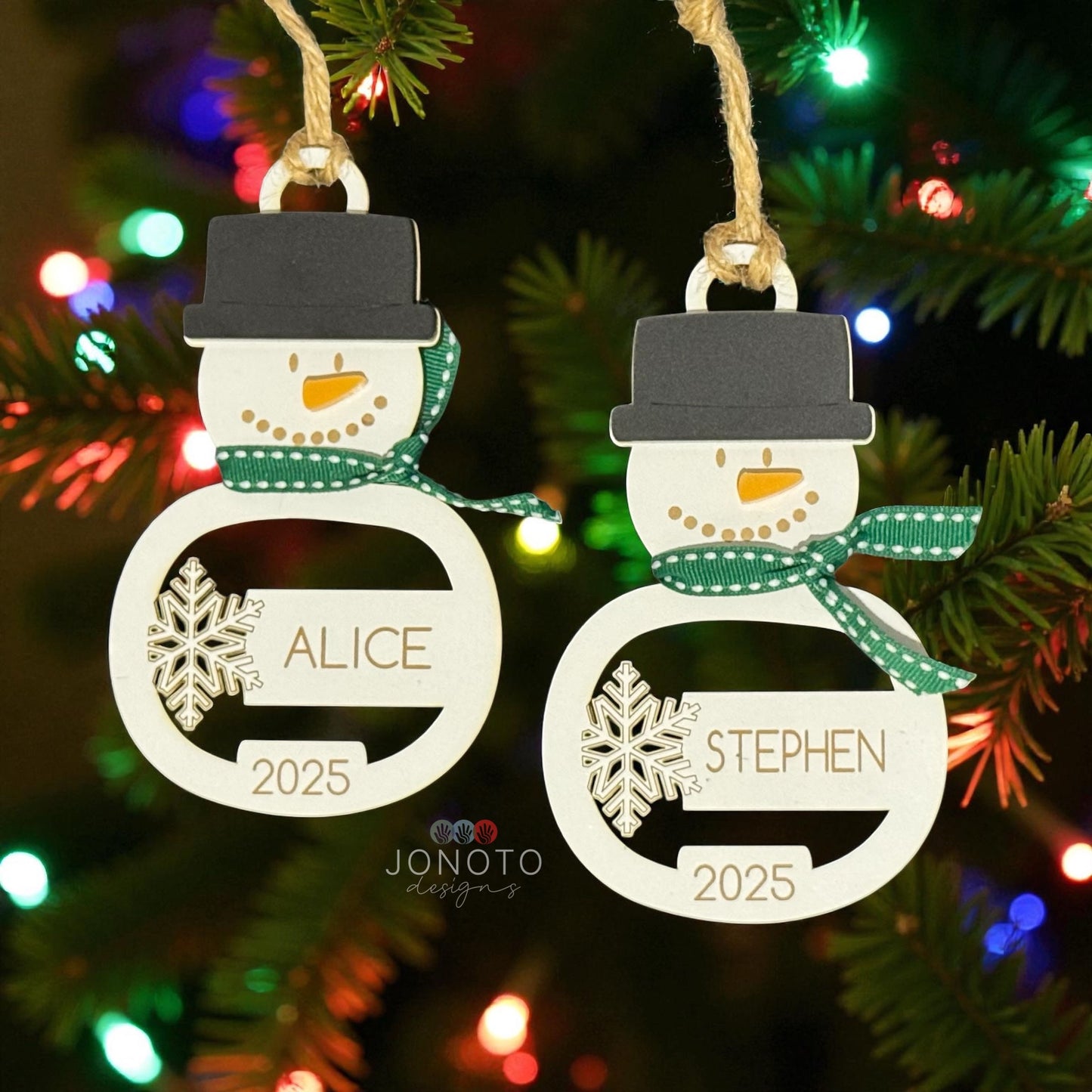Two snowman-shaped Christmas ornaments with personalized names and the year 2025, hanging against a festive background.